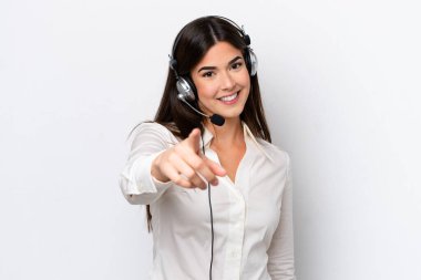 Beyaz arka planda izole edilmiş bir kulaklıkla çalışan beyaz pazarlamacı kadın kendinden emin bir ifadeyle sana parmak basıyor.