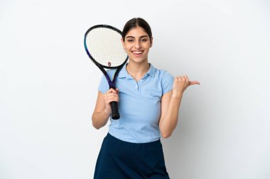 Yakışıklı genç tenisçi beyaz arka planda izole edilmiş beyaz kadın bir ürünü sunmak için kenarı işaret ediyor.