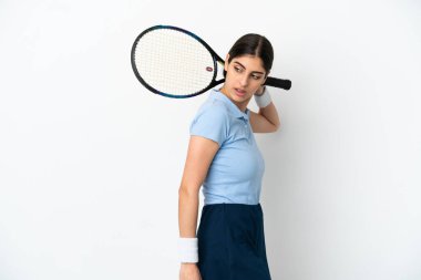 Beyaz arka planda tenis oynayan beyaz tenli genç kadın.