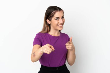 Beyaz arka planda izole edilmiş genç beyaz kadın şaşırmış ve ön tarafı işaret ediyor.