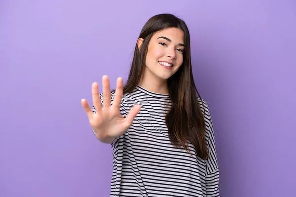 Young Brazilian woman isolated on purple background counting five with fingers