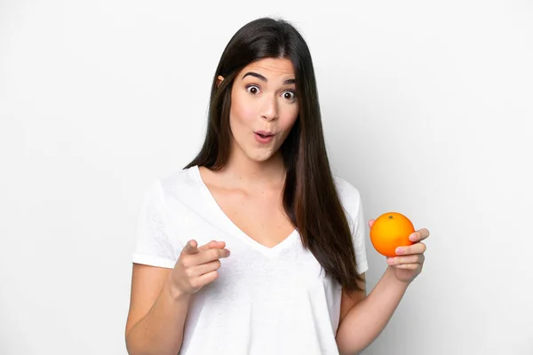 Young Brazilian Woman Holding Orange Isolated White Background Surprised Pointing — Stock Photo, Image