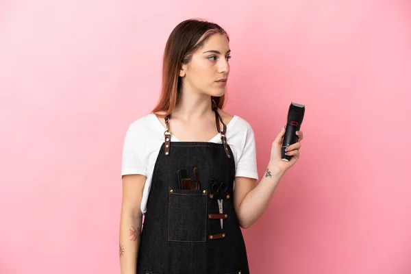 Ung Frisör Kvinna Isolerad Rosa Bakgrund Tittar Sidan — Stockfoto