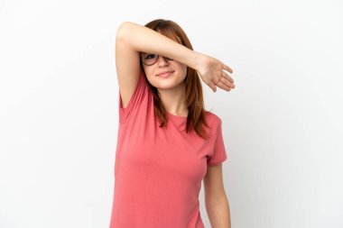 Kızıl saçlı kız beyaz arka planda izole edilmiş gözleri elleriyle kapatıyor.