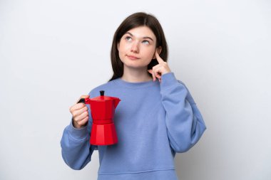 Beyaz arka planda kahve demliği tutan genç Rus kadının şüpheleri ve düşünceleri vardı.