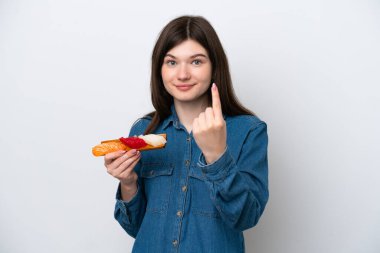 Beyaz arka planda saşimi tutan genç bir Rus kadın geliyor.