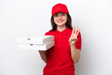 Genç Rus pizza teslimatı beyaz arka planda izole edilmiş pizza kutularını alıyor mutlu ve parmaklarıyla üçe kadar sayıyor.