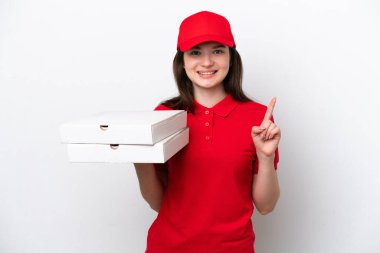 Genç Rus pizza teslimatı beyaz arka planda izole edilmiş pizza kutularını alıyor ve en iyinin işareti olarak parmağını kaldırıyor.