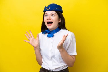 Airplane stewardess Russian woman isolated on yellow background with surprise facial expression