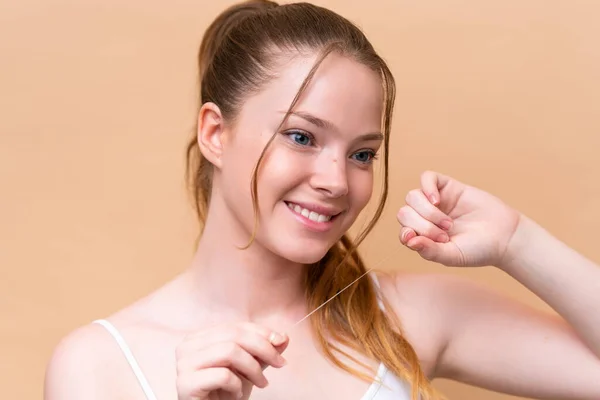 Young Caucasian Girl Isolated Beige Background Dental Floss Close Portrait — Stockfoto
