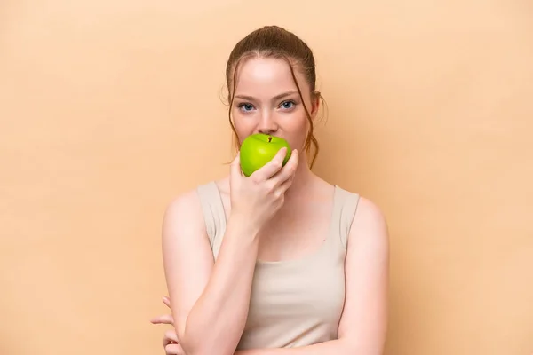 Young Caucasian Girl Isolated Beige Background Eating Apple — Fotografia de Stock