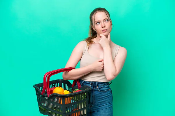 Young Woman Holding Shopping Basket Full Food Isolated Green Background — Stockfoto