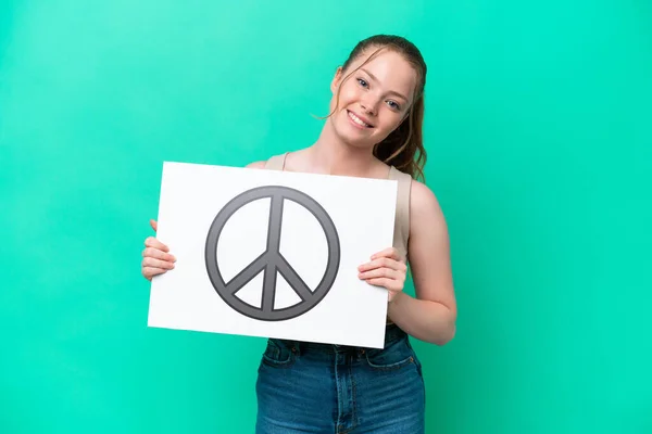 Young Caucasian Woman Isolated Green Background Holding Placard Peace Symbol — Stok fotoğraf