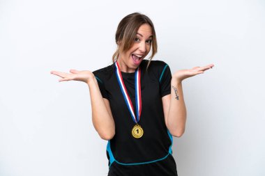 Beyaz arka planda, yüzünde şok ifadesi olan, madalyalı beyaz bir kadın.