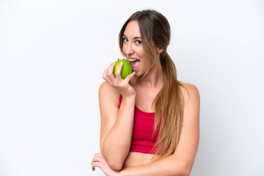 Beyaz arka planda izole edilmiş beyaz bir kadın elma yiyor.