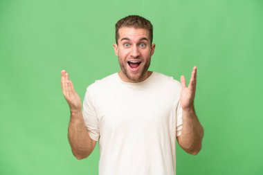 Yeşil krom arka planda yalıtılmış yakışıklı, beyaz bir adam. Sürpriz bir yüz ifadesi var.