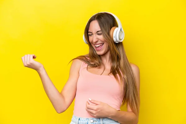 Joven Mujer Caucásica Aislada Sobre Fondo Amarillo Escuchando Música Haciendo —  Fotos de Stock