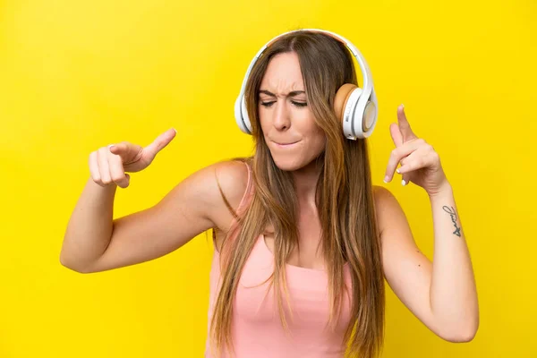 Joven Mujer Caucásica Aislada Sobre Fondo Amarillo Escuchando Música Bailando —  Fotos de Stock