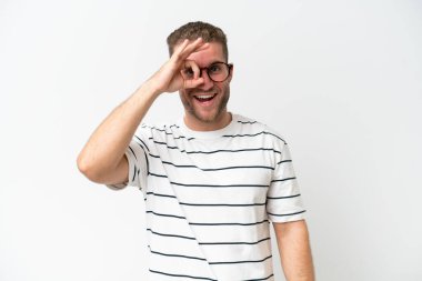 Beyaz arka planda izole edilmiş yakışıklı beyaz adam parmaklarıyla işaret veriyor.