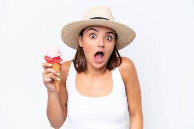 Kornet dondurması olan beyaz arka planda şaşırmış ve şok olmuş yüzü olan beyaz bir kadın.