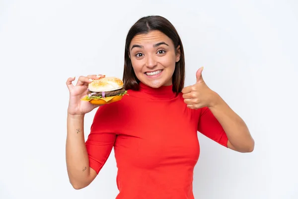 Młoda Biała Kobieta Trzyma Hamburgera Białym Tle Kciukami Górze Stało — Zdjęcie stockowe