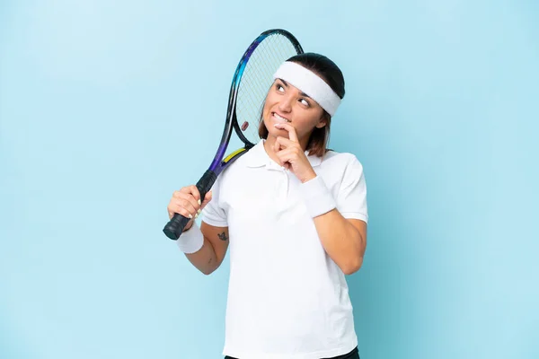 Joven Jugadora Tenis Aislada Sobre Fondo Azul Teniendo Dudas Pensando — Foto de Stock