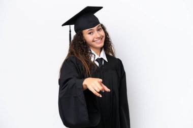 Üniversite mezunu genç bir Arap kadın beyaz arka planda izole edilmiş. Kendine güvenen bir ifadeyle seni işaret ediyor.