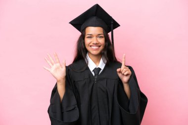 Kolombiyalı genç bir üniversite mezunu, pembe arka planda izole edilmiş, parmaklarıyla altı kişi sayıyor.