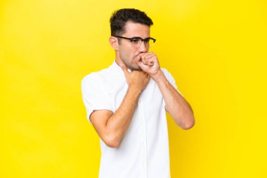 Genç yakışıklı adam, izole edilmiş sarı arka planda çok öksürüyor.