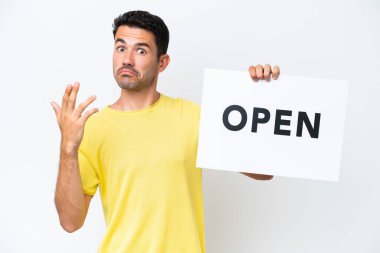 İzole edilmiş beyaz arka planda genç yakışıklı bir adam. Elinde açık yazılı bir pankart tutuyor ve gelecek vadeden bir jest yapıyor.