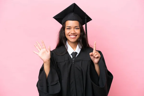Young university Colombian woman graduate isolated on pink background counting six with fingers