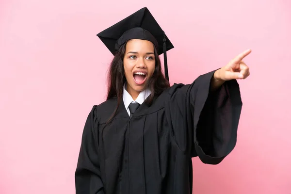 若い大学コロンビア人女性卒業ピンクの背景に離れて指して隔離 — ストック写真