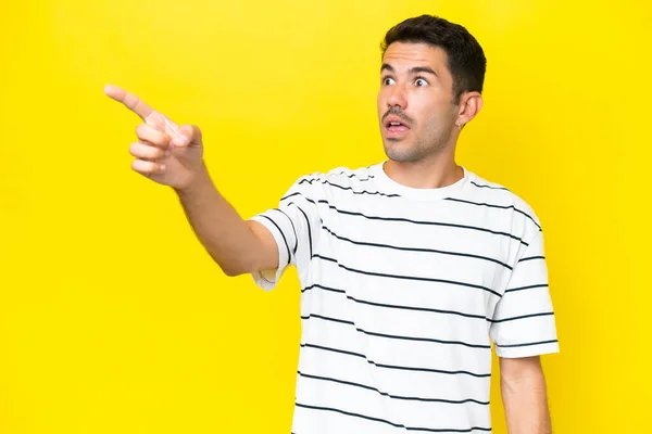 Jovem Homem Bonito Sobre Isolado Fundo Amarelo Apontando Para Longe — Fotografia de Stock