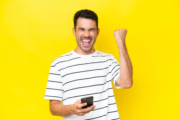 Joven Hombre Guapo Sobre Fondo Amarillo Aislado Con Teléfono Posición —  Fotos de Stock