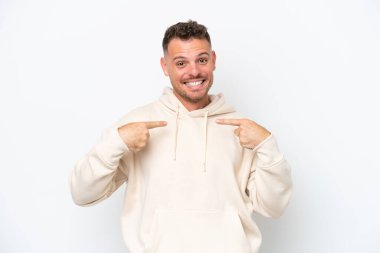 Beyaz arka planda yüzü şaşırmış, beyaz tenli yakışıklı genç bir adam.