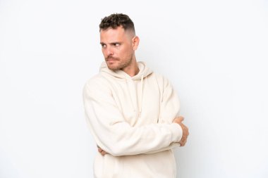 Young caucasian handsome man isolated on white background keeping the arms crossed