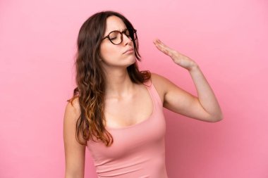 Pembe arka planda izole edilmiş, yorgun ve hasta bir yüzü olan beyaz bir kadın.