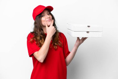 Pizza dağıtan kadın iş üniformalı beyaz arka planda izole edilmiş pizza kutuları alıyor mutlu ve gülümsüyor.
