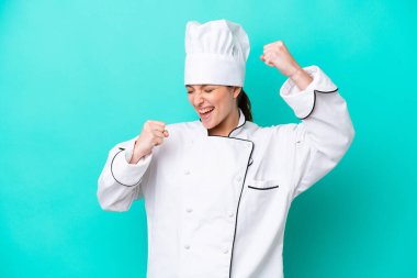 Kafkasyalı genç aşçı kadın mavi arka planda tek başına zaferi kutluyor.