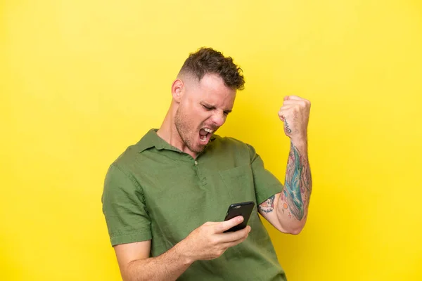 Young Caucasian Handsome Man Isolated Yellow Background Phone Victory Position — Stock Photo, Image