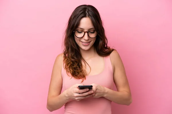 Pembe Arka Planda Izole Edilmiş Genç Beyaz Kadın Cep Telefonuyla — Stok fotoğraf