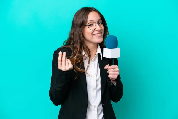 Young TV presenter woman isolated on blue background making money gesture