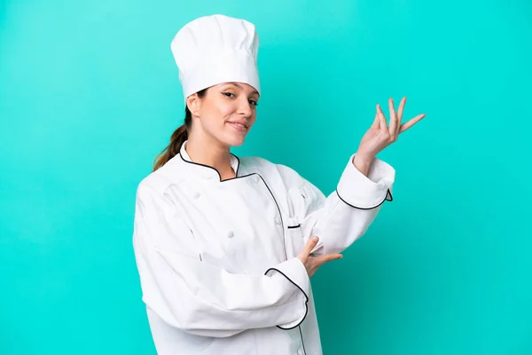 Jovem Mulher Chef Caucasiano Isolado Fundo Azul Estendendo Mãos Para — Fotografia de Stock