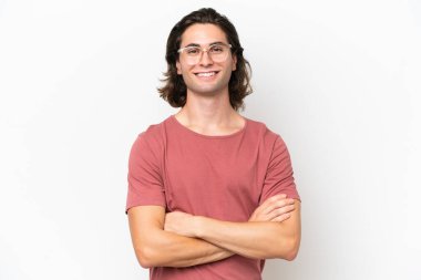 Beyaz arka planda izole genç yakışıklı adam kollarını ön cephede çapraz tutuyor.