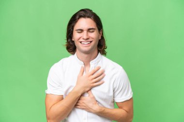 Yeşil krom arka planda izole edilmiş genç beyaz adam çok gülümsüyor.