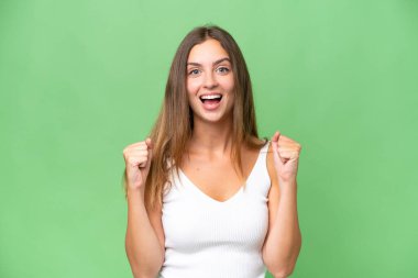 Galibiyet pozisyonundaki zaferi kutlayan izole edilmiş genç ve güzel bir kadın.