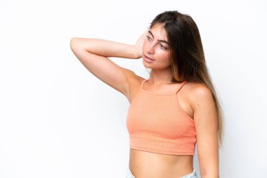 Beyaz arka planda izole edilmiş genç beyaz kadın elini kulağına koyarak bir şeyler dinliyor.