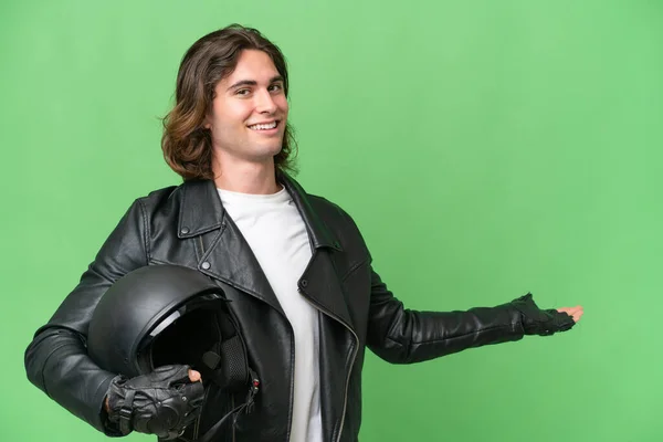 若いですハンサムな男とともにAオートバイヘルメット隔離上の緑クロマバック拡張手へザ側への招待 — ストック写真