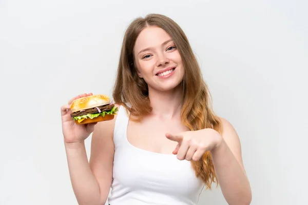 Молода Красива Жінка Тримає Бургер Ізольовано Білому Тлі Вказує Пальцем — стокове фото