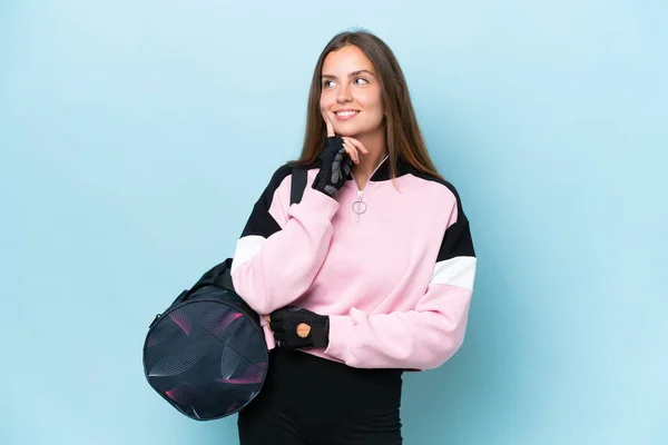 Giovane Donna Sportiva Con Borsa Sportiva Isolata Sfondo Blu Pensando — Foto Stock